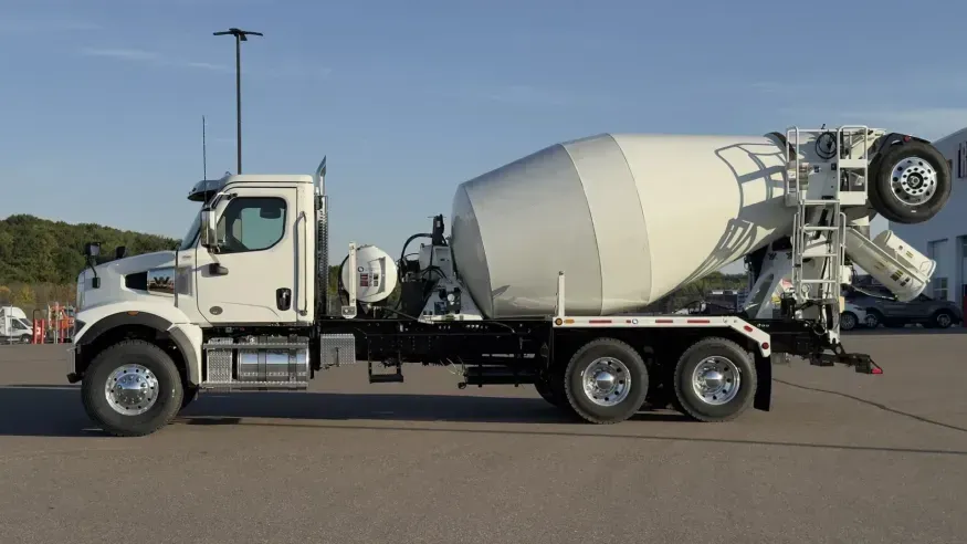 A commercial rotating-drum mixer truck on its chassis, viewed from the side