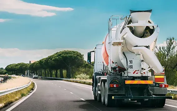 A rotating-drum ready-mix truck traveling on a highway — ready-mix concrete insurance in Ohio